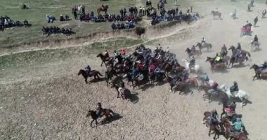 At sürüsi Tacikistan'daki Karakol festivalinde geleneksel oyun sırasında drone Korkmuş at tan görünümü bacaklarının üzerinde duruyor. Bu byt keçi leşi korktum.