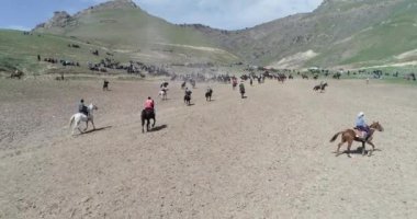 At sürüsi Tacikistan'daki Karakol festivalinde geleneksel oyun sırasında drone Korkmuş at tan görünümü bacaklarının üzerinde duruyor. Bu byt keçi leşi korktum.