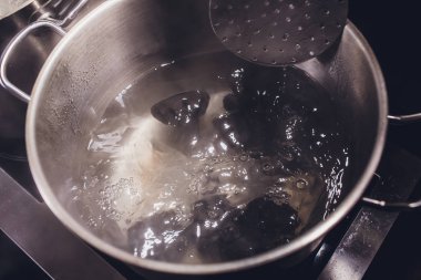 khinkali veya köfte buhar yoluyla bir tencerede soba üzerinde kaynamış suda kaynatılır. Yemek. siyah renk.