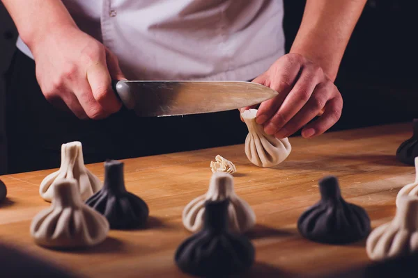 Cocina georgiana nacional Fondo metálico de Khinkali Cook prepara cocina khinkali Vista superior plato de masa de carne cruda cabina de alimentos sin cocer venta de especialidad china Dumplings al vapor Proceso de cocción . — Foto de Stock