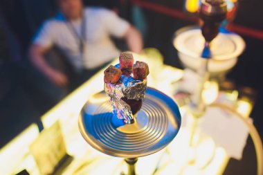 Kırmızı kömürlü Shisha nargile. Nefes alışından kıvılcımlar. Rahatlamak ve tüttürmek için hindistan cevizi kömürlü modern nargile. Nargile ve kömürden kıvılcımlar. Başka bir manzara. Shisha, kıvılcım, kıvılcım, nargile kıvılcımı.