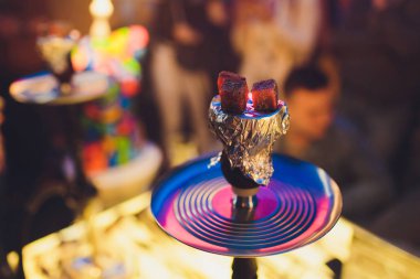 Kırmızı kömürlü Shisha nargile. Nefes alışından kıvılcımlar. Rahatlamak ve tüttürmek için hindistan cevizi kömürlü modern nargile. Nargile ve kömürden kıvılcımlar. Başka bir manzara. Shisha, kıvılcım, kıvılcım, nargile kıvılcımı.