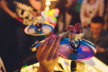 Kırmızı kömürlü Shisha nargile. Nefes alışından kıvılcımlar. Rahatlamak ve tüttürmek için hindistan cevizi kömürlü modern nargile. Nargile ve kömürden kıvılcımlar. Başka bir manzara. Shisha, kıvılcım, kıvılcım, nargile kıvılcımı.