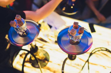 Kırmızı kömürlü Shisha nargile. Nefes alışından kıvılcımlar. Rahatlamak ve tüttürmek için hindistan cevizi kömürlü modern nargile. Nargile ve kömürden kıvılcımlar. Başka bir manzara. Shisha, kıvılcım, kıvılcım, nargile kıvılcımı.