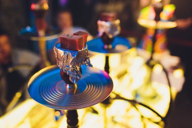 Kırmızı kömürlü Shisha nargile. Nefes alışından kıvılcımlar. Rahatlamak ve tüttürmek için hindistan cevizi kömürlü modern nargile. Nargile ve kömürden kıvılcımlar. Başka bir manzara. Shisha, kıvılcım, kıvılcım, nargile kıvılcımı.