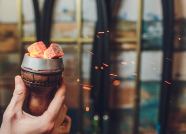 Kırmızı kömürlü Shisha nargile. Nefes alışından kıvılcımlar. Rahatlamak ve tüttürmek için hindistan cevizi kömürlü modern nargile. Nargile ve kömürden kıvılcımlar. Başka bir manzara. Shisha, kıvılcım, kıvılcım, nargile kıvılcımı.