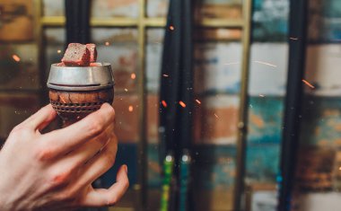 Kırmızı kömürlü Shisha nargile. Nefes alışından kıvılcımlar. Rahatlamak ve tüttürmek için hindistan cevizi kömürlü modern nargile. Nargile ve kömürden kıvılcımlar. Başka bir manzara. Shisha, kıvılcım, kıvılcım, nargile kıvılcımı.