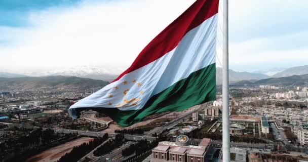 Bandera de Tayikistán en asta de bandera contra el cielo azul tonificación moderna — Vídeos de Stock