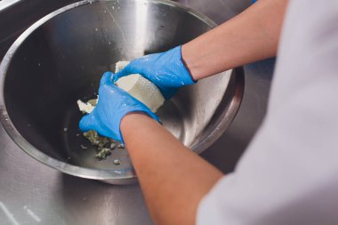 Geleneksel peynir yapımı bir küçük şirket. Peynir Maker eller yakın çekim üstten görünüm.