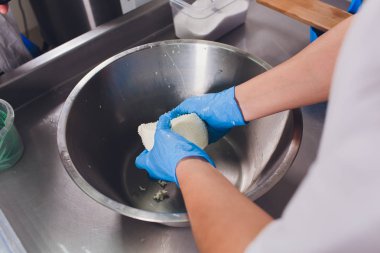 Geleneksel peynir yapımı bir küçük şirket. Peynir Maker eller yakın çekim üstten görünüm.