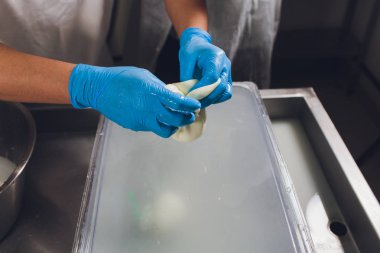 Esnaf cheesemaker elleri ile mozzarella keser.