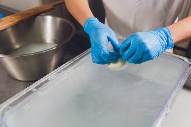 Esnaf cheesemaker elleri ile mozzarella keser.