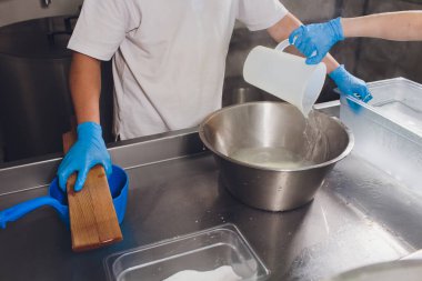 Geleneksel peynir yapımı bir küçük şirket. Peynir Maker eller yakın çekim üstten görünüm.