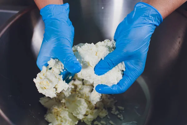 Fabricación tradicional de quesos en una pequeña empresa. Queso fabricante manos primer plano vista superior . — Foto de Stock