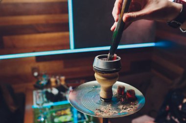 adam nargile atmosferik içinde nargile üzerinde kömürleri değiştirerek.