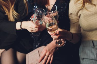 Partide insanların elinde şampanya bardakları.