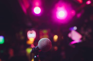 Sahnede oditoryumun arka planına karşı mikrofon.