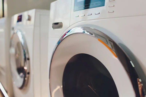 Uma fileira de máquinas de lavar roupa industriais em uma lavanderia pública . — Fotografia de Stock