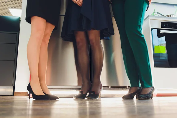 Benen van zakenlui. Vrouw dragen van rok, kousen en hoge hakken, man het dragen van donkere broeken en schoenen. — Stockfoto