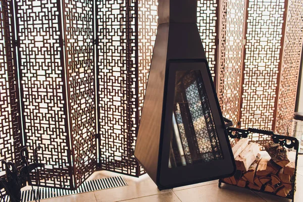 Elegante habitación moderna con chimenea, moderna chimenea con bisagras, negro en forma de triángulo, contra la ventana . — Foto de Stock