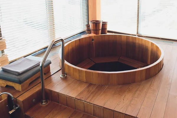 Bañera de hidromasaje tomando un baño de relajación en la sauna al lado de la ventana . — Foto de Stock