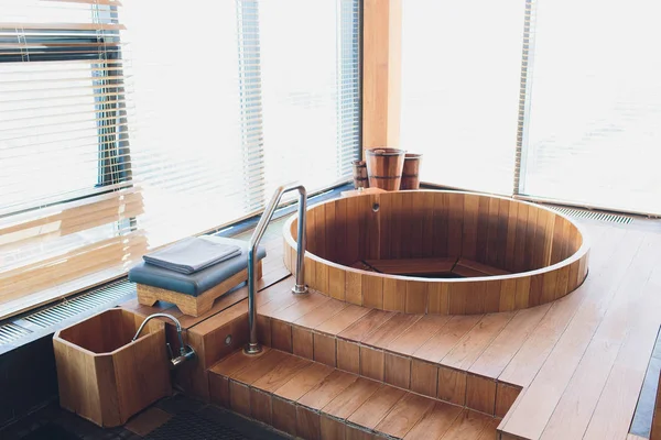 Bañera de hidromasaje tomando un baño de relajación en la sauna al lado de la ventana . — Foto de Stock