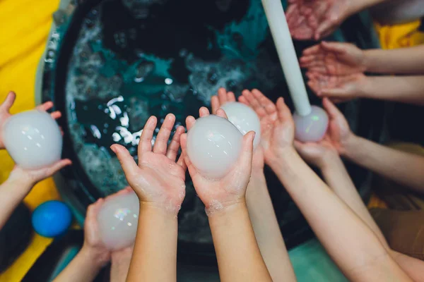 Niños jugando con burbujas al aire libre, enfoque selectivo muchas manos, vista superior . —  Fotos de Stock