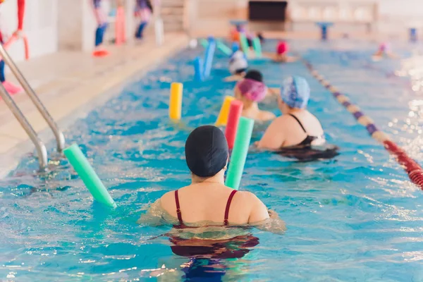 Ženy trénují v aqua aerobiku, učí se plavat. — Stock fotografie
