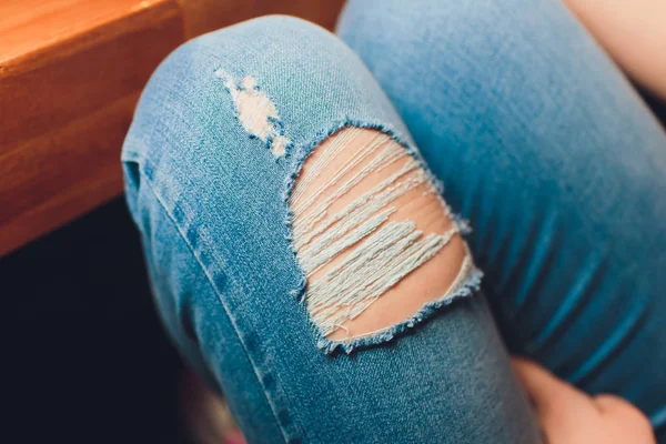 Woman in torn jeans blue texture fashion.