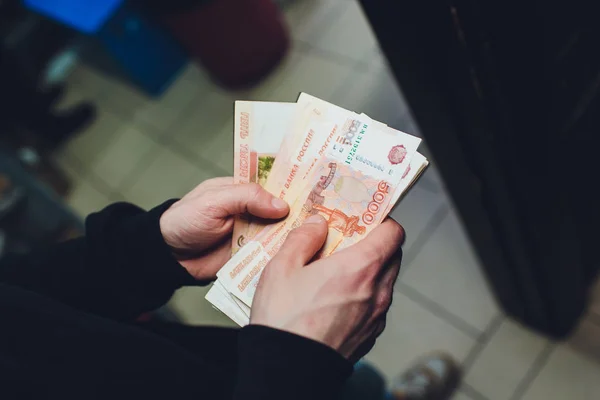 Мужчина держит в руках рубли и доллары, бизнесмен держит в руках деньги . — стоковое фото