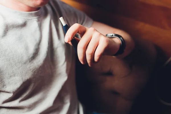 Tecnología de productos de tabaco sin combustión por calor. Hombre sosteniendo el cigarrillo electrónico en su mano antes de fumar . — Foto de Stock