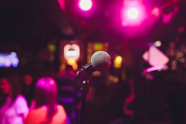 Microfoon op het podium tegen een achtergrond van auditorium. — Stockfoto
