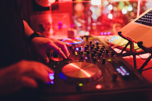 DJ mesa giratoria mezclador de consola de control con dos manos en el escenario de discoteca concierto . — Foto de Stock