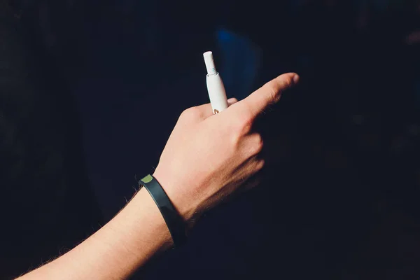 heat-not-burn tobacco product technology. Man holding e-cigarette in his hand before smoking.