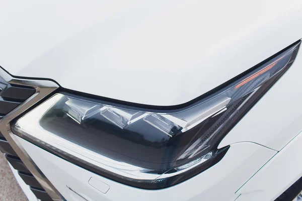 Närbild av strålkastare detalj av modern lyxbil med projektor objektiv för låg och hög balk. Främre bild av sport crossover fordonets strålkastare. Begreppet Bildetaljer och ljus teknik bakgrund. — Stockfoto