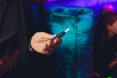 ısı-değil-tütün ürünü teknolojisi yakmak. Sigara içmeden önce elinde e-sigara tutan adam.