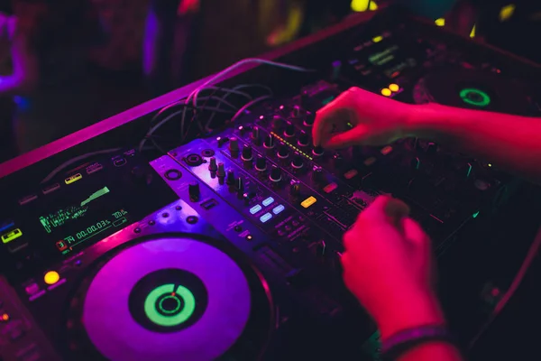 DJ mesa giratória console mixer controle com duas mãos no palco da boate concerto . — Fotografia de Stock