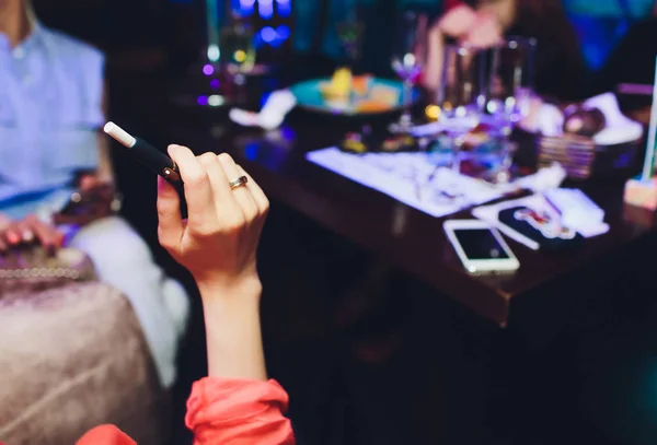 Tecnologia dei prodotti del tabacco non bruciati termicamente. Donna che tiene la sigaretta elettronica in mano prima di fumare. — Foto Stock