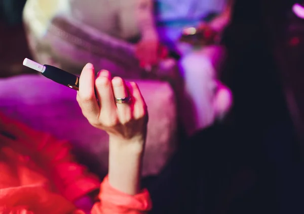 Τεχνολογία προϊόντων καπνού που δεν καίγονται με θερμότητα. Γυναίκα κρατώντας ένα ηλεκτρονικό τσιγάρο στο χέρι του πριν από το κάπνισμα. — Φωτογραφία Αρχείου