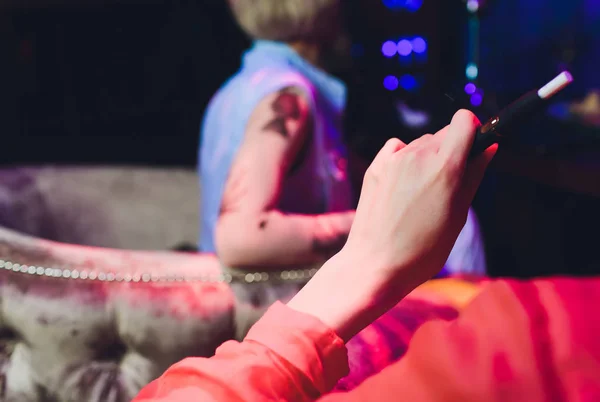 Technologie für hitzebeständige Tabakerzeugnisse. Frau hält vor dem Rauchen E-Zigarette in der Hand. — Stockfoto