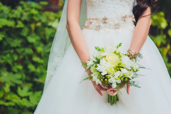 Mooie bruiloft boeket van bloemen in de handen van de bruid. — Stockfoto