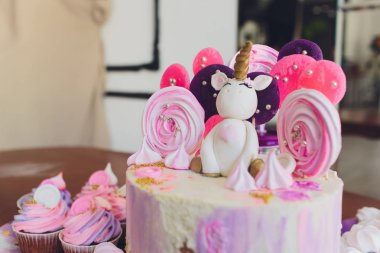 Güzel bir parlak pasta mavi kitaplık içinde fantezi tek boynuzlu at şeklinde dekore edilmiştir. Şenlikli bir tatlı çocuklar doğum günü için kavramı.