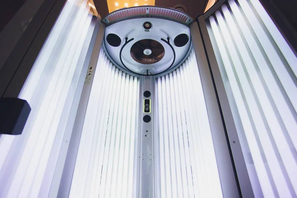 Vertical Tanning turbo Solarium Light Machine com luz azul brilhante lâmpadas ultravioletas para bronzeamento e cuidados com a pele. Bronzeamento vazio Solário moderno, por dentro. Abra a porta do Solário. Painel de controle no lado . — Fotografia de Stock