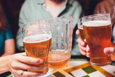 Barmen elini bira fıçısına koyup bira dökerken yakın plan..