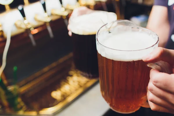 Крупним планом рука бармена під пивним краном, що поливає пиво з осадкою . — стокове фото