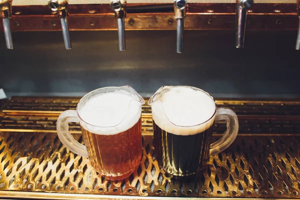 Close-up of barman hand at beer tap pouring a draught lager beer. — Stock Photo, Image