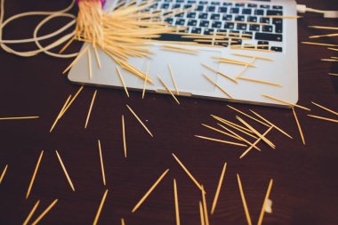 kahverengi masa arka planda birçok ahşap kürdan bir dizüstü bilgisayar.