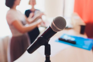 Sahnede oditoryumun arka planına karşı mikrofon.