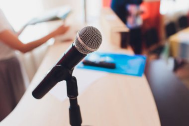 Sahnede oditoryumun arka planına karşı mikrofon.