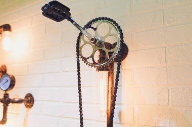 İç mimari tarzı tasarım unsuru Steampunk. Lamba ampul aydınlatmalı ekipman kapalı asılı aydınlatma demir sanayi dişli cogwheels Zincir Dişli üzerinde sabit.